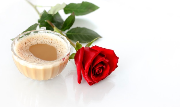 Caffè del mattino e una rosa rossa isolata