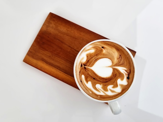 Caffè del negozio laterale Vista dall'alto una tazza di caffè caldo latte art su piatto di legno