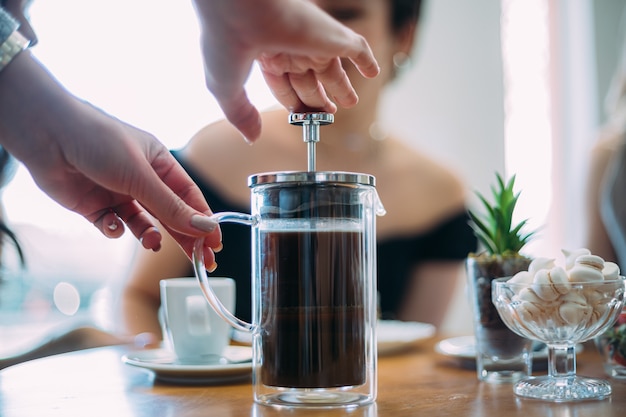 Caffè della stampa francese. Amici in attesa di un caffè al tavolo in una caffetteria brasiliana.