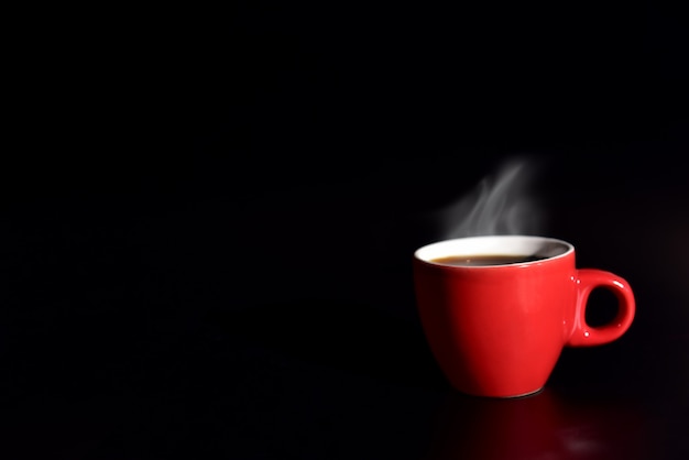 Caffè della tazza rossa su fondo nero per il concetto di amore. Bere e rilassare il concetto