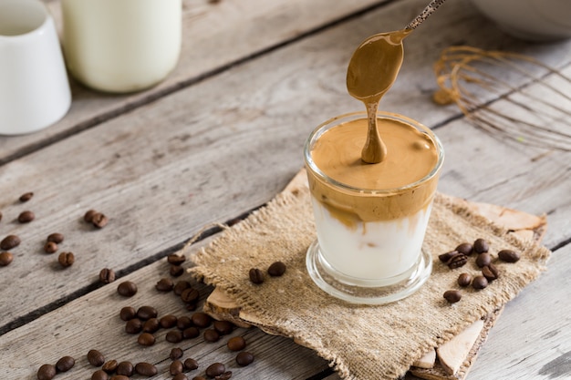 Caffè di Dalgona in un bicchiere su un tavolo di legno