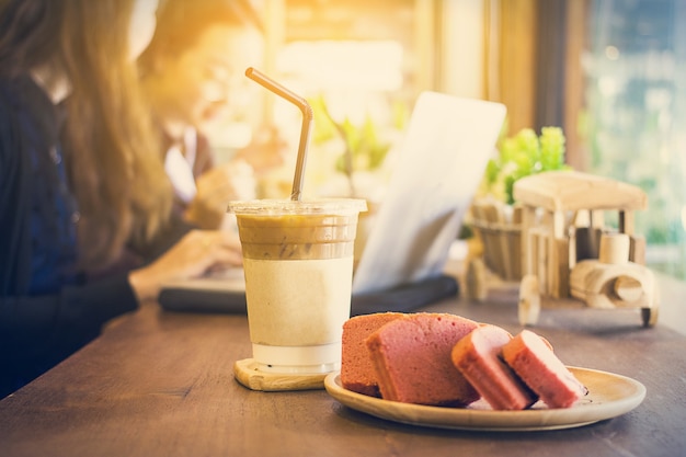 Caffè di ghiaccio in tazza di caffè e torta dessert usa e getta durante il tempo di lavoro