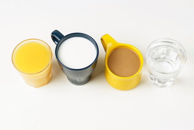 Caffè e altre bevande in tazze colorate su sfondo bianco vista dall'alto