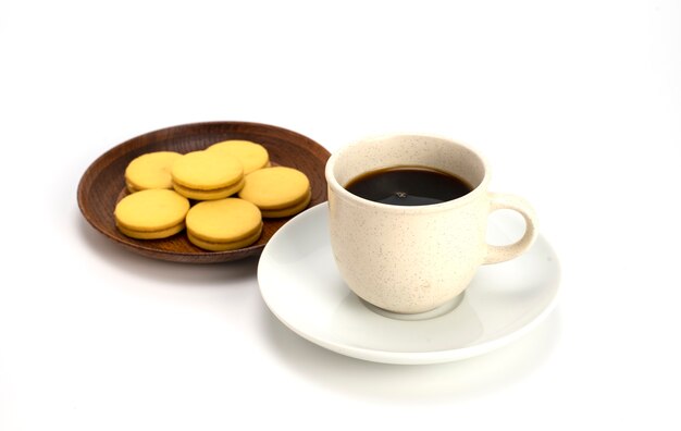 Caffè e biscotti ripieni in un piatto separato su sfondo bianco.