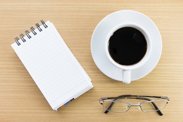 Caffè e blocco note sul tavolo di legno