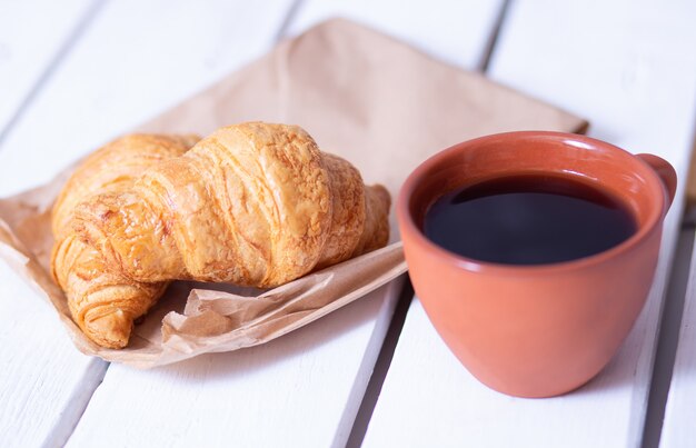 Caffè e cornetti su un tavolo di legno bianco