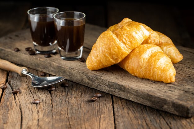 Caffè e cornetti sulla parete di legno, vista dall'alto