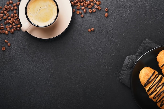 Caffè e croissant Caffè espresso e croissant con cioccolato su vecchio su tavolo di cemento nero Croissant perfetto Colazione al mattino Stile rustico Vista dall'alto Mock up