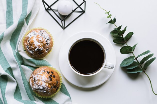 Caffè e due muffin sulla superficie bianca