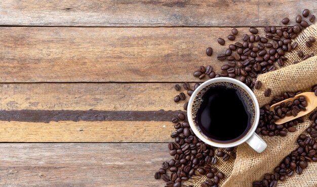 Caffè e fagiolo caldi su fondo di legno. vista dall'alto