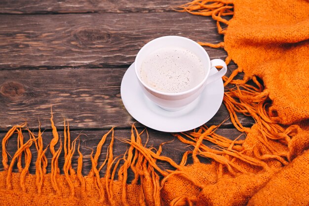 caffè e foglie autunnali su fondo in legno