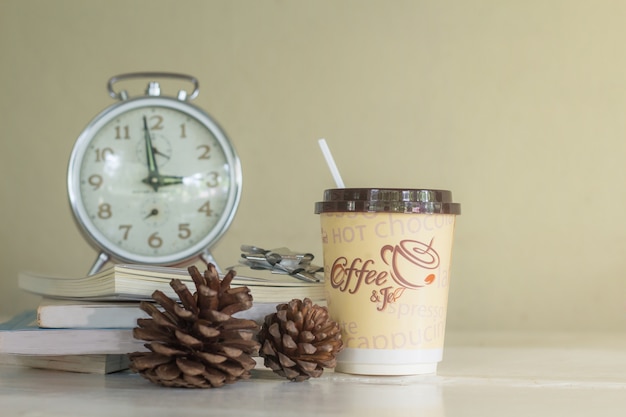 Caffè e libro caldi sulla tabella di legno con la priorità bassa di colore