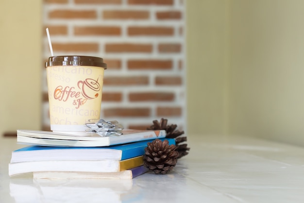 Caffè e libro caldi sulla tavola di legno con il fondo di colore, concetto