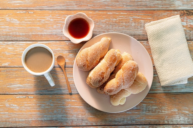 Caffè e pane in tavolaMuffin ai mirtilli appena sfornati in ambiente rustico con latte