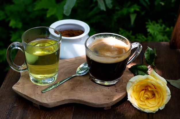 Caffè e tè sono sul tavolo di legno in giardino verde