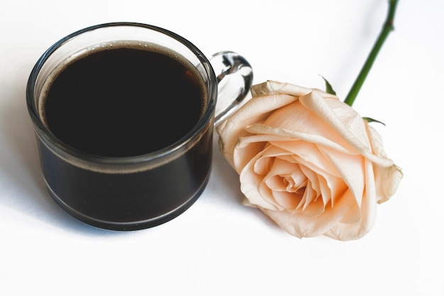 Caffè e una rosa gialla su sfondo bianco