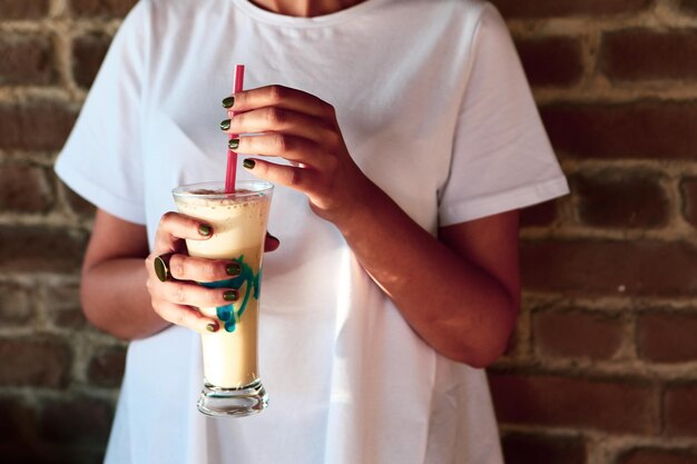 Caffè freddo con latte Caffè freddo latte Donna che tiene tazza di vetro di caffè freddo