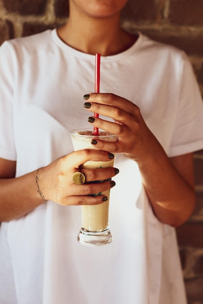 Caffè freddo con latte Caffè freddo latte Donna che tiene tazza di vetro di caffè freddo