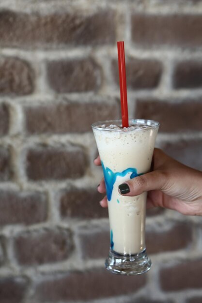 Caffè freddo con latte Caffè freddo latte Donna che tiene tazza di vetro di caffè freddo