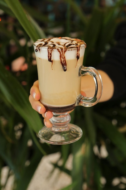 Caffè freddo con latte Caffè freddo latte Donna che tiene tazza di vetro di caffè freddo