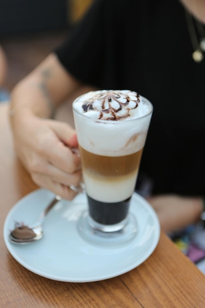 Caffè freddo con latte Caffè freddo latte Donna che tiene tazza di vetro di caffè freddo