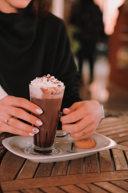 Caffè freddo con latte. Latte freddo al caffè. Donna che tiene una tazza di caffè freddo in vetro.