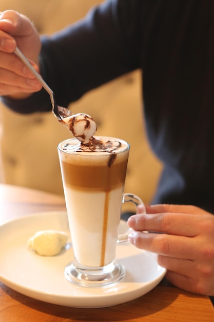 Caffè freddo con latte. Latte freddo al caffè. Donna che tiene una tazza di caffè freddo in vetro.