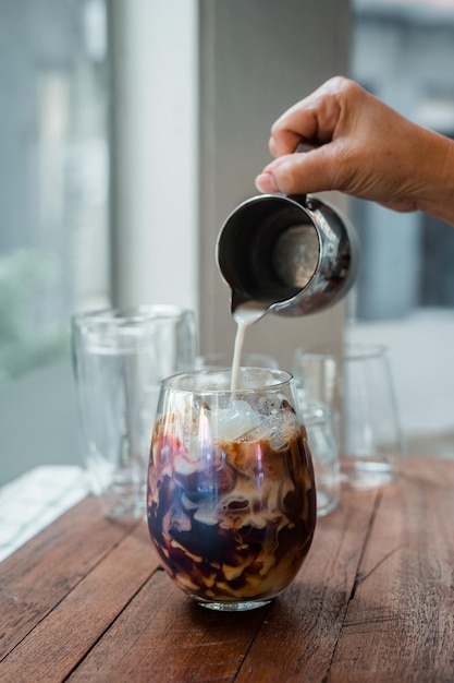 caffè freddo con latte servito sul tavolo nero di un bar