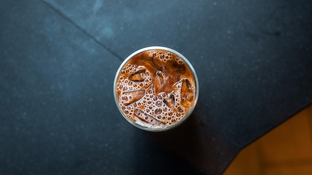 caffè freddo con latte servito sul tavolo nero in un bar