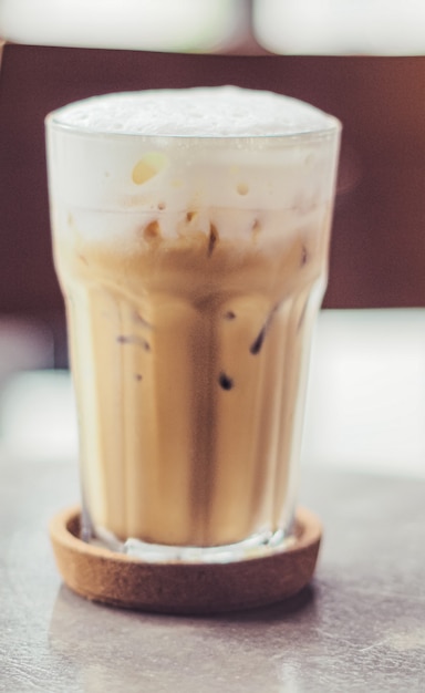 Caffè freddo in un bicchiere alto trasparente con latte o panna sopra
