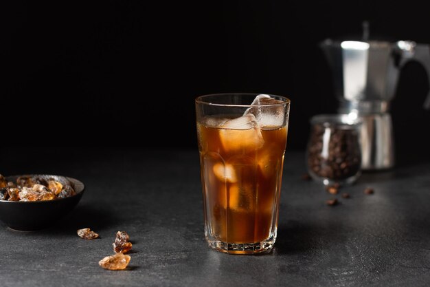 Caffè freddo in un bicchiere su sfondo nero