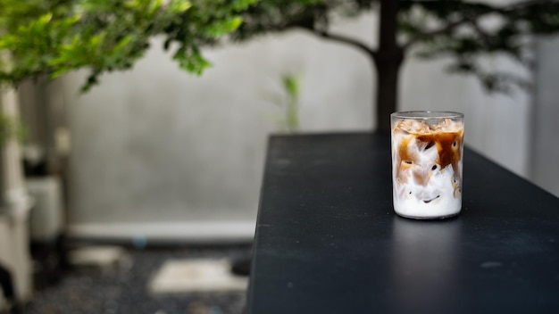 Caffè ghiacciato con latte in un bicchiere su un tavolo in un bar