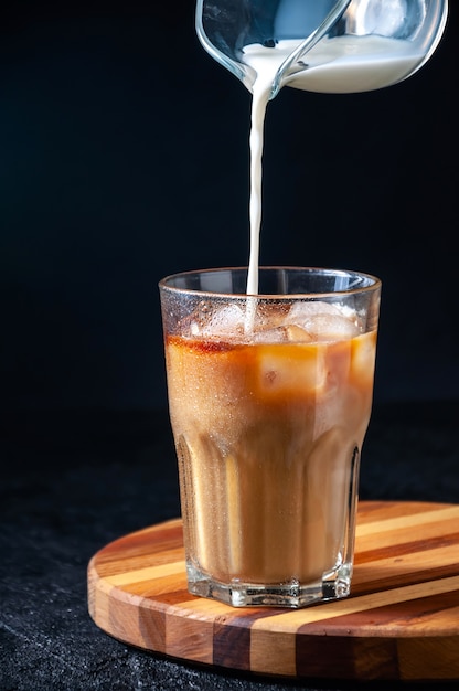 Caffè ghiacciato in un bicchiere su sfondo scuro