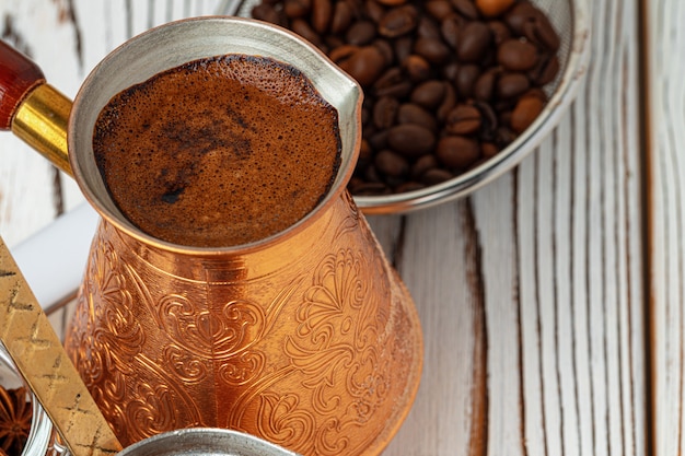 Caffè in metallo turco con spezie in un piatto