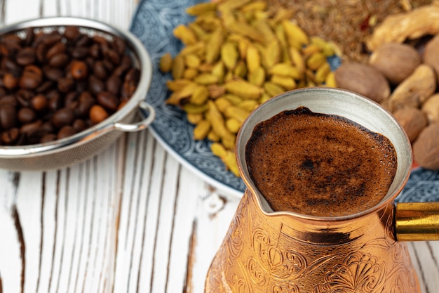 Caffè in metallo turco con spezie in un piatto