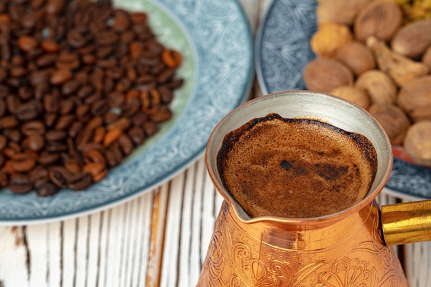 Caffè in metallo turco con spezie in un piatto