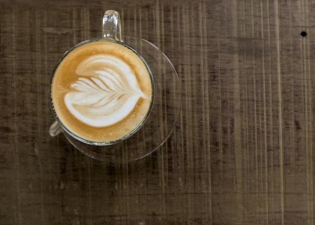 Caffè in ritardo caldo su fondo di legno