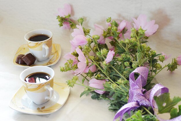 Caffè in tazza, caramelle, fiori e una confezione regalo