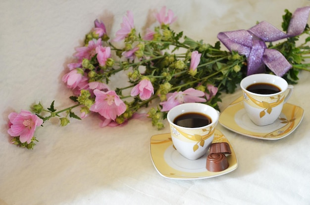 Caffè in tazza, caramelle, fiori e una confezione regalo