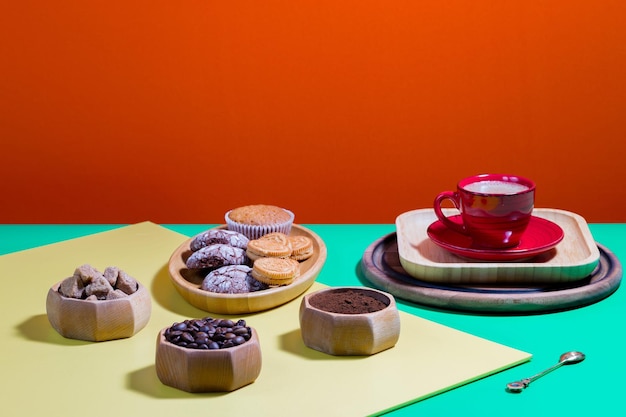 Caffè in tazza con dessert su uno sfondo colorato brillante