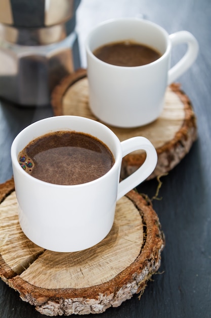 Caffè in tazze bianche su tavole di legno