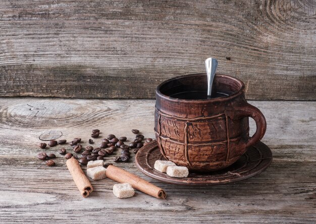 Caffè in una grande tazza in ceramica sulla vecchia tavola di legno.