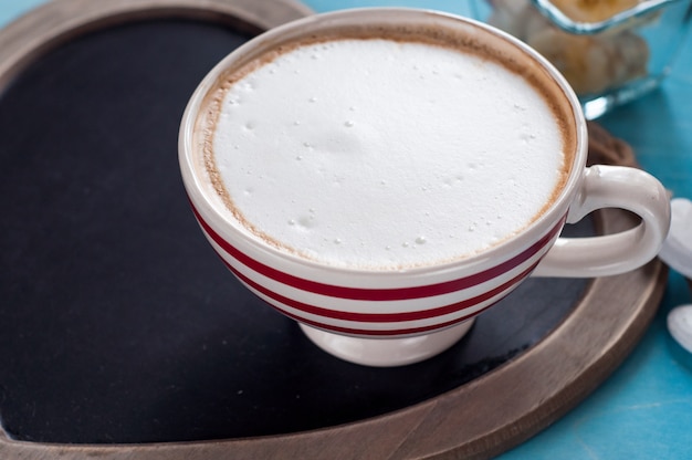 Caffè in una tazza bianca con strisce rosse