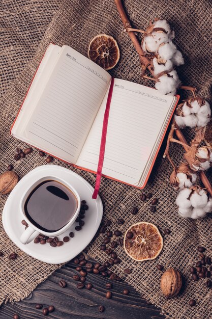 Caffè in una tazza con un blocco note e una vista superiore di stile piano del cotone