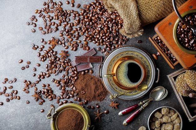 Caffè in una tazza e piattino con chicchi di caffè