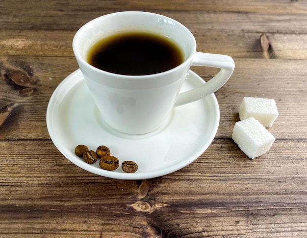 Caffe' in una tazza e zucchero sul tavolo.