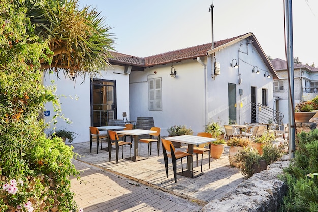 Caffè in una vecchia casa con tavoli sotto i raggi del sole al tramonto