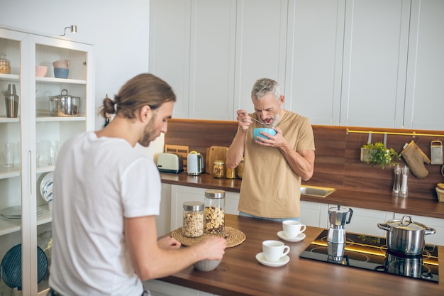 Caffè insieme. Coppie sorridenti che bevono caffè e parlano in cucina