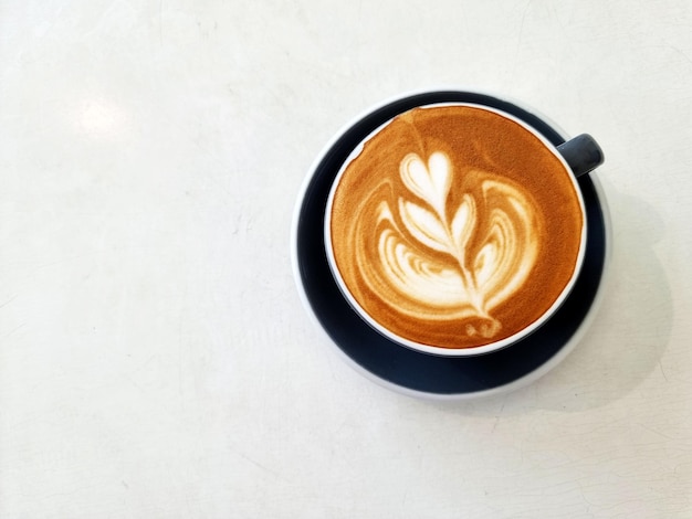 Caffè laterale del negozio una tazza di caffè caldo di arte del latte sul tavolo