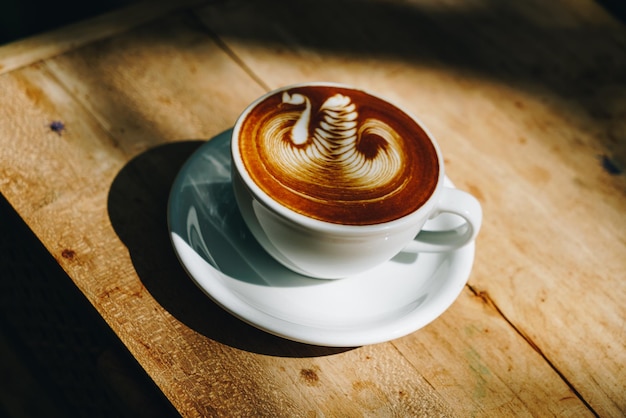 Caffè latte art in tazza bianca